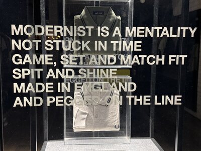 Fred Perry fashion display with polo shirt in glass vitrine, philosophical slogan MODERNIST IS A MENTALITY NOT STUCK IN TIME, boutique window